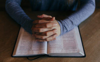Man praying over Bible